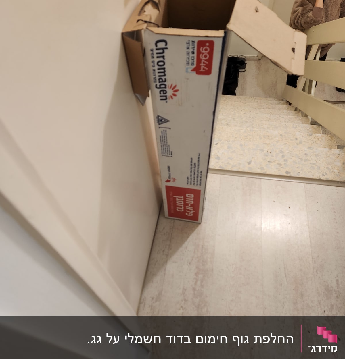 קופסת כרומגן פתוחה מונחת על רצפה ליד מדרגות